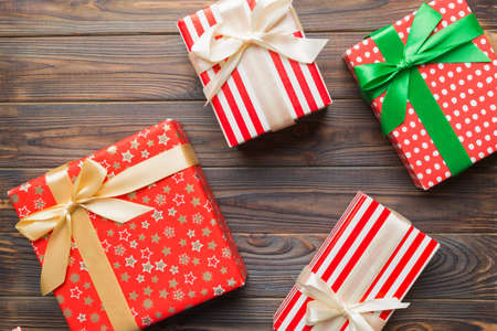 A lot of Christmas gift boxes in colored paper decorated on table, Top view close up. Many present...