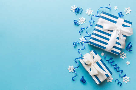 Holiday flat lay with gift boxes wrapped in colorful paper and tied decorated with confetti on colored background. Christmas, Birthday, Valentine and sale concept, top view.の写真素材