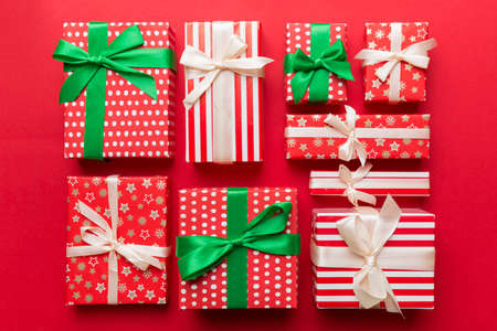 A lot of Christmas gift boxes in colored paper decorated on table, Top view close up. Many present...