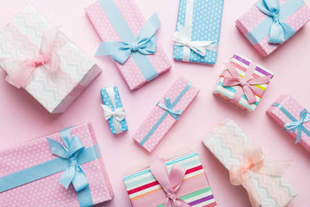 A lot of Christmas gift boxes in colored paper decorated on table, Top view close up. Many present...