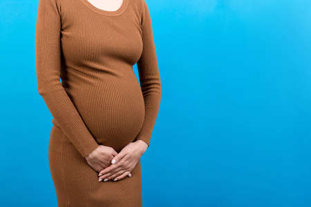 urinary incontinence during pregnancy. Abdominal pain during pregnancy. Maternity healthcare concept on colored background.の写真素材