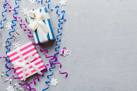 Holiday flat lay with gift boxes wrapped in colorful paper and tied decorated with confetti on...
