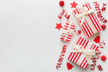 Holiday flat lay with gift boxes wrapped in colorful paper and tied decorated with confetti on...