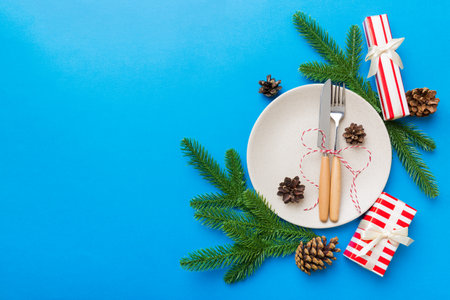 Christmas table place setting with christmas decor and plates, kine, fork and spoon. Christmas holiday background. Top view with copy space.の写真素材