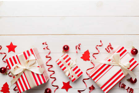 Holiday flat lay with gift boxes wrapped in colorful paper and tied decorated with confetti on colored background. Christmas, Birthday, Valentine and sale concept, top view.の写真素材