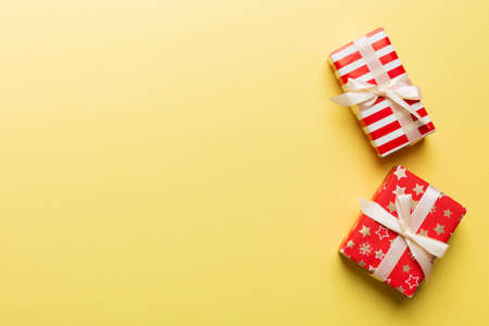 Holiday flat lay with gift boxes wrapped in colorful paper and tied decorated with confetti on colored background. Christmas, Birthday, Valentine and sale concept, top view.の写真素材