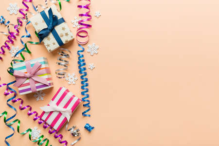 Holiday flat lay with gift boxes wrapped in colorful paper and tied decorated with confetti on colored background. Christmas, Birthday, Valentine and sale concept, top view.の写真素材