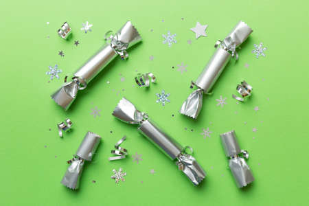 Christmas crackers with shiny confetti on color background, top view, copy space.の写真素材