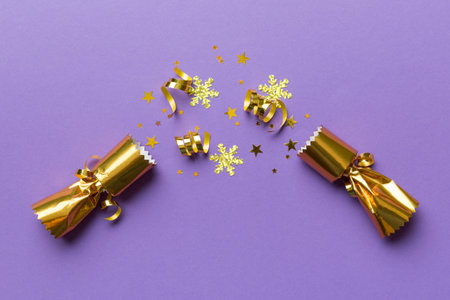 Christmas crackers with shiny confetti on color background, top view, copy space.の写真素材