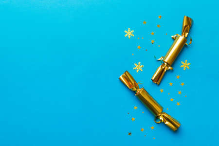 Christmas crackers with shiny confetti on color background, top view, copy space.の写真素材