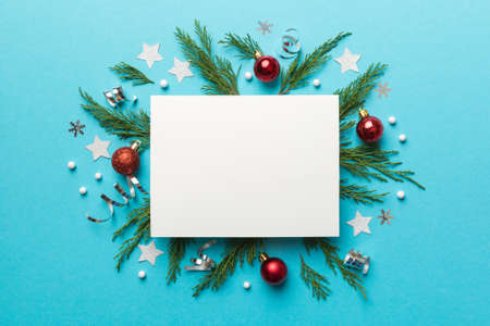 Flat lay Christmas composition. square Paper blank, pine tree branches, christmas decorations on Colored background. Top view, copy space for text.の写真素材