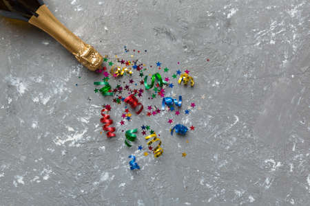 Creative flat lay composition with bottle of champagne and space for text on color background. Champagne bottle with colorful party streamers. holiday or christmas concept.の写真素材