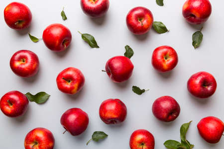 Many red apples on colored background, top view. Autumn pattern with fresh apple above view.の写真素材