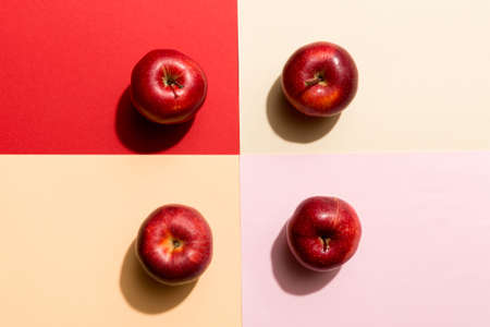 Many red apples on colored background, top view. Autumn pattern with fresh apple above view.の写真素材