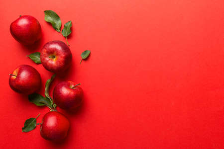 Many red apples on colored background, top view. Autumn pattern with fresh apple above view with...