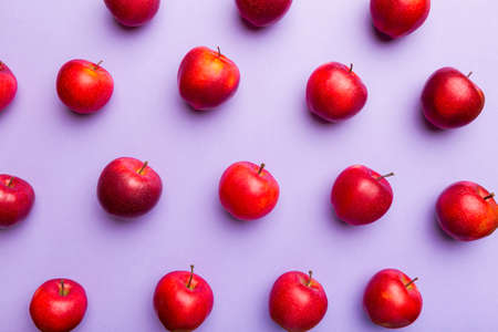 Many red apples on colored background, top view. Autumn pattern with fresh apple above view.の写真素材
