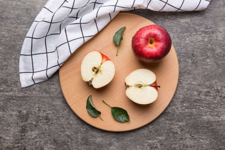 Fresh red apples with green leaves on table. cutting board with knife. Top view.