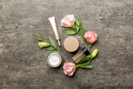 Composition with cosmetic products and beautiful roses on cement background. Flat lay.の写真素材