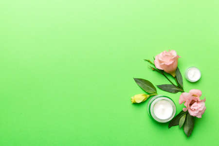 Composition with cosmetic products and beautiful roses on wooden background. Copy space, flat lay.