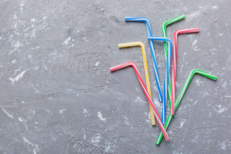 Drinking straws for party on Colored background. Top view of colorful plastic disposable straws for summer cocktails. different straws for juice with copy space.の写真素材