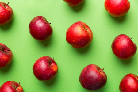 Many red apples on colored background, top view. Autumn pattern with fresh apple above view.の写真素材