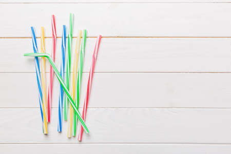 Drinking straws for party on Colored background. Top view of colorful plastic disposable straws for summer cocktails. different straws for juice with copy space.の写真素材