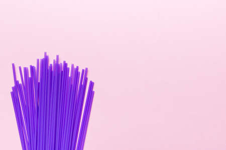 Heap of colorful plastic drinking straws on Colored background, flat lay. Copy Space for text.の写真素材