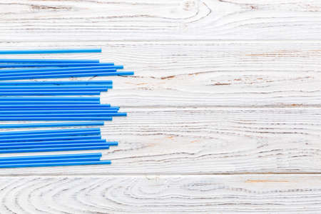 Heap of colorful plastic drinking straws on Colored background, flat lay. Copy Space for text.