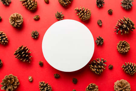 Creative frame made of Christmas pine cones with square Paper blank. Xmas and New Year theme. Flat lay, top view copy space.の写真素材