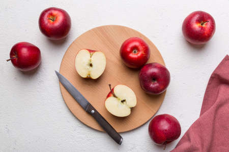 Fresh red apples with green leaves on table. cutting board with knife. Top view.の写真素材