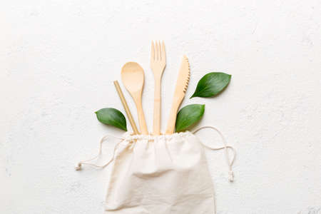 Eco friendly reusable recyclable white eco bag with kitchenware on Colored background. Concept zero...
