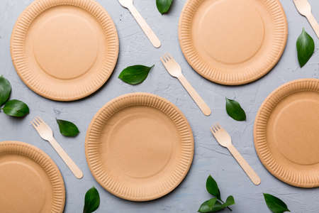 set of empty reusable disposable eco-friendly plates, cups, utensils on light white colored table background. top view. Biodegradable craft dishes. Recycling concept. Close-up.の写真素材
