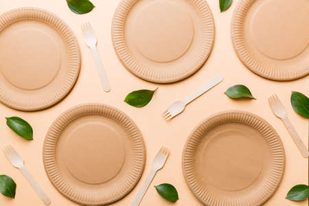 set of empty reusable disposable eco-friendly plates, cups, utensils on light white colored table background. top view. Biodegradable craft dishes. Recycling concept. Close-up.の写真素材