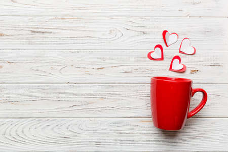 red cup on colored background, splashes of red little hearts, top view with copy space.の写真素材