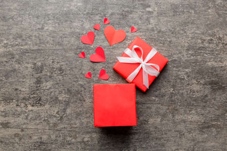 Happy valentines day opened heart shape gift box with small hearts, on colored background, valentines day card - top view concept.の写真素材