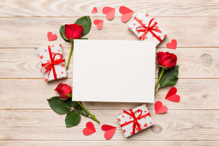 Frame made of rose, git box, heart and blank greeting card mockup on Colored background. Top view, flat lay, copy space Holiday, Mothers Day, birthday concept.の写真素材