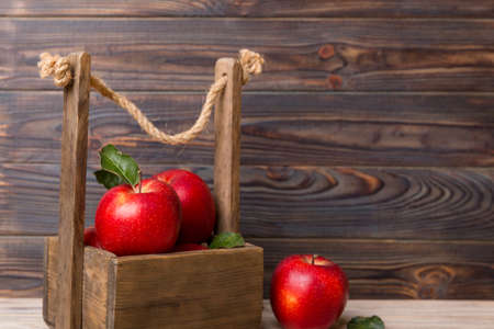 Ripe red apples in wooden box. On a white wooden background.の写真素材