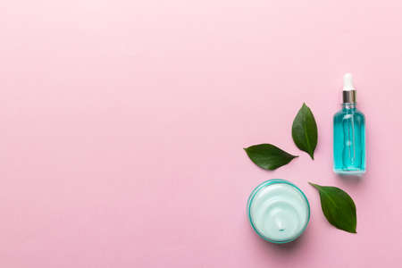 Organic cosmetic products with green leaves on color background. Copy space, flat lay.の写真素材