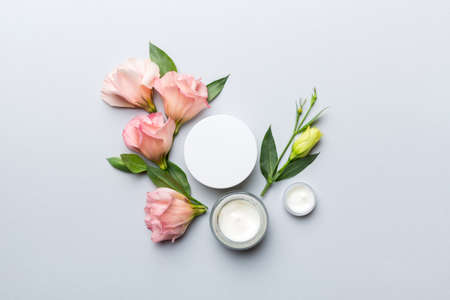 Composition with cosmetic products and beautiful roses on color background. Flat lay.の写真素材