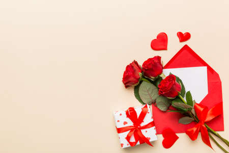 Valentine day composition with Envelope, rose flower and Red heart on table. Top view, flat lay. Holiday concept.の写真素材
