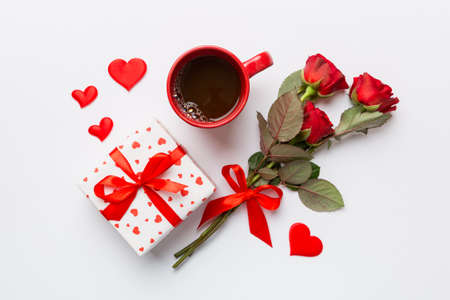 Valentine day composition with coffee cup, rose flower and gift box on table. Top view, flat lay. Holiday concept.の写真素材