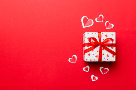 Valentine day composition: red gift box with bow and heart. Christmas present. View from above....
