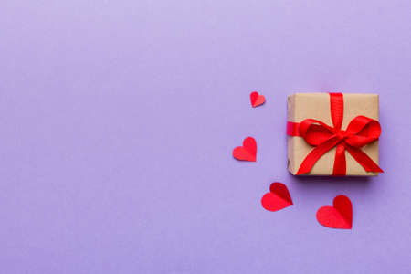 Valentine day composition: red gift box with bow and heart. Christmas present. View from above....