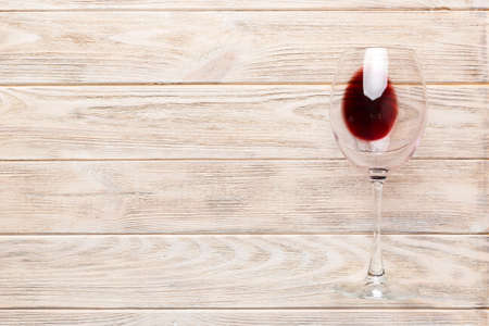 One glasses of red wine at wine tasting. Concept of red wine on colored background. Top view, flat lay design.の写真素材