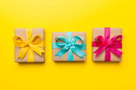 Holiday present box over colored background, top view.