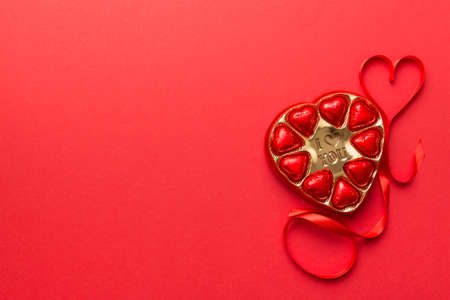 Delicious chocolate pralines in red box for Valentine's Day. Heart shaped box of chocolates top view with copy space.の写真素材