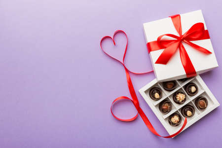 Delicious chocolate pralines in red box for Valentine's Day. Heart shaped box of chocolates top view with copy space.の写真素材