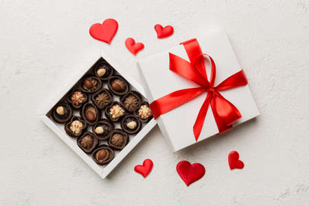 Delicious chocolate pralines in red box for Valentine's Day. Heart shaped box of chocolates top view with copy space.の写真素材