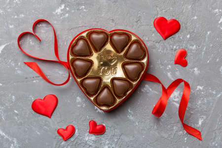 Delicious chocolate pralines in red box for Valentine's Day. Heart shaped box of chocolates top view with copy space.の写真素材