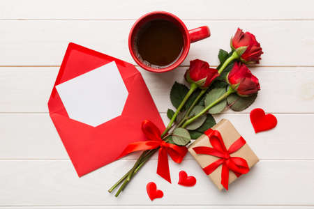 Valentine day composition with coffee cup, rose flower and gift box on table. Top view, flat lay. Holiday concept.の写真素材